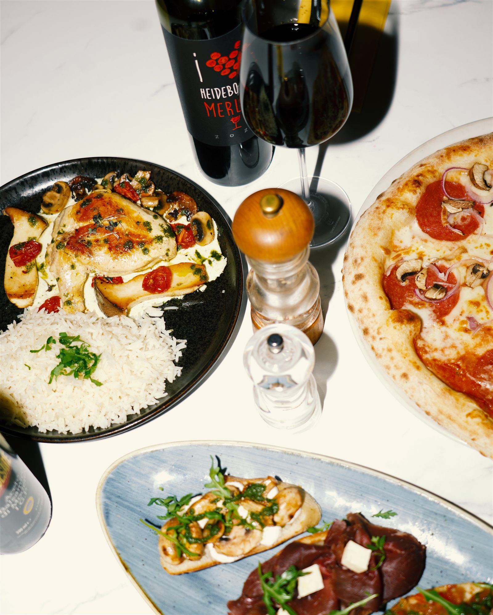 Gedeckter Tisch mit Wein, Pizza und Antipasti